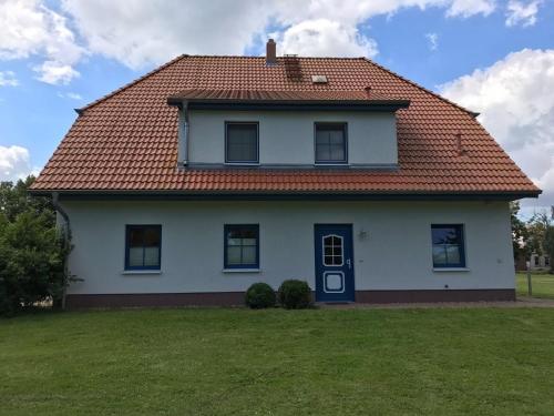 a white house with a red roof at Dycke Haus 6 in Garz-Rügen