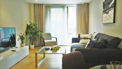 a living room with a couch and a tv at Spacious & Elegant Apartments in Southbank near London Eye in London