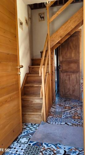 a room with a staircase and a wooden door at La Quë Dou Queur in Cantoira