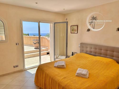 - une chambre avec un grand lit jaune et un balcon dans l'établissement Villa Les Freesias - Grande Piscine - Vue sur Mer, à Carqueiranne