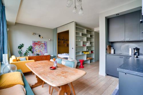 Il comprend une cuisine et un salon avec une table en bois. dans l'établissement 1BR Flat with Balcony near the Eiffel Tower, à Paris