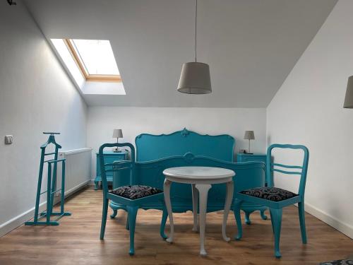 a dining room with blue chairs and a table at Glam One Bedroom Duplex in Vila in city centre in Arad