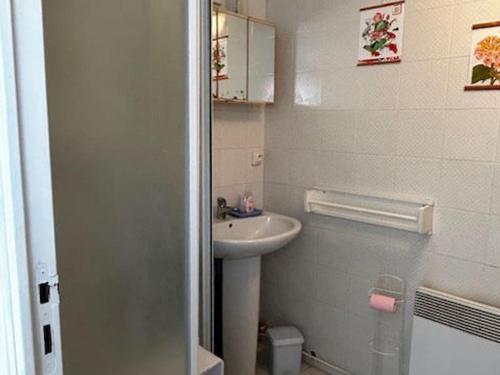 une salle de bain blanche avec un lavabo et un miroir dans l'établissement Studio au RDC d'une maison, à Quend-Plage