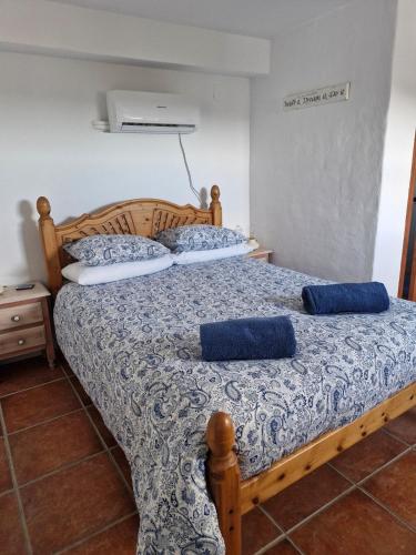 a bedroom with two beds with blue pillows on them at Casa Araflo in Cortijada Los Chorreros