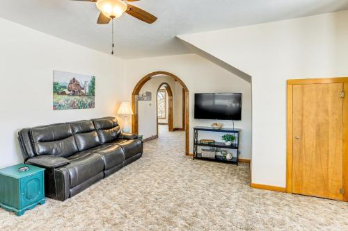 a living room with a leather couch and a flat screen tv at Patio and Mountain Views Farmhouse in Mancos! in Mancos