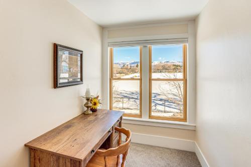 a dining room with a wooden table and a window at Patio and Mountain Views Farmhouse in Mancos! in Mancos