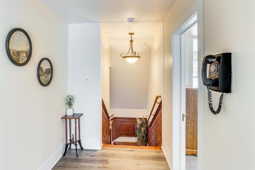a hallway with a clock and a tv on a wall at Patio and Mountain Views Farmhouse in Mancos! in Mancos