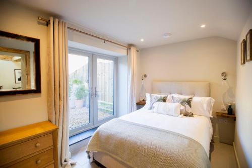 a bedroom with a bed and a large window at Mowhay Barn in Bodmin