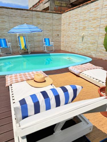 a hat sitting on a chair next to a swimming pool at Casa com piscina em Florianópolis in Florianópolis
