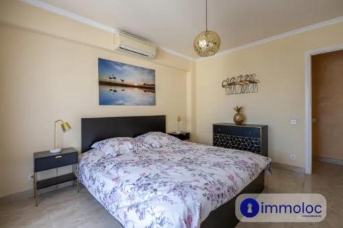 une chambre avec un lit avec un couvre-lit fleuri dans l'établissement Air-conditioned apartment with terrace sea view, à Nice