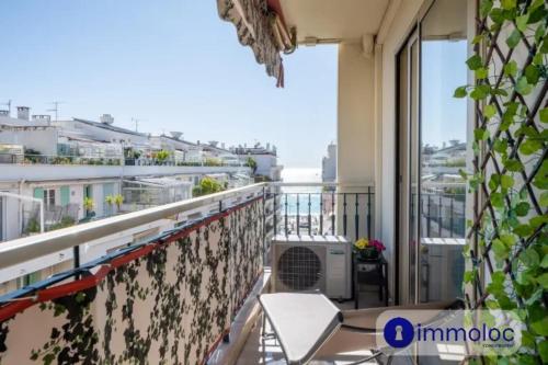 d'un balcon avec une chaise blanche et une fenêtre. dans l'établissement Air-conditioned apartment with terrace sea view, à Nice