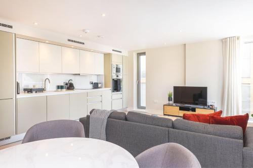 a living room with a couch and a kitchen at Spacious & Elegant Apartments in Southbank near London Eye in London