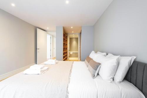 a bedroom with a large white bed with white pillows at Spacious & Elegant Apartments in Southbank near London Eye in London