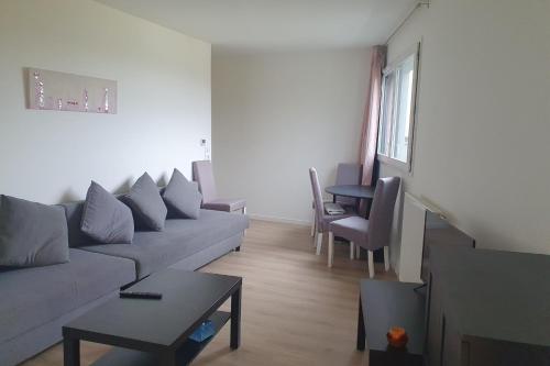 un salon avec un canapé et une table dans l'établissement Charming T3 with balcony near Paris, à Villejuif