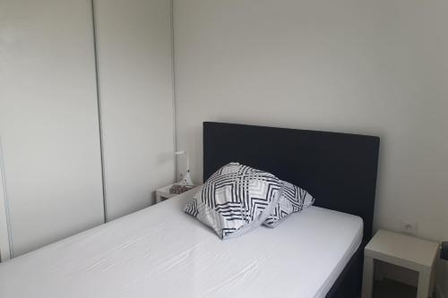- un lit avec un oreiller en noir et blanc dans l'établissement Charming T3 with balcony near Paris, à Villejuif