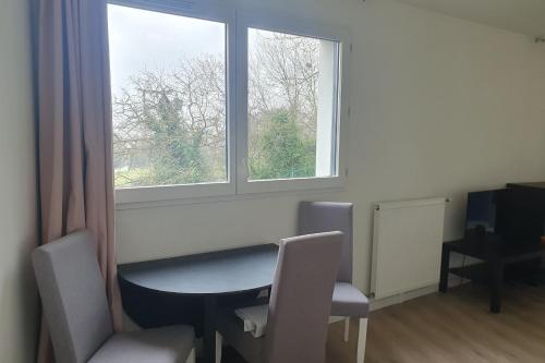 une pièce avec une table, des chaises et une fenêtre dans l'établissement Charming T3 with balcony near Paris, à Villejuif