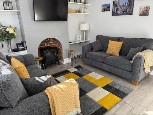 a living room with two couches and a fireplace at Archie's Cottage in Lincoln