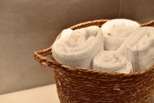 a basket filled with white towels on a table at Palermo Inn Boutique Hotel in Palermo