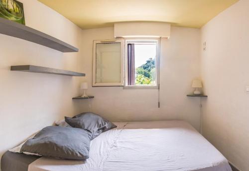 une petite chambre avec un lit et une fenêtre dans l'établissement T2 Proche Polygone - piscine, parking privé, fibre, à Cagnes-sur-Mer