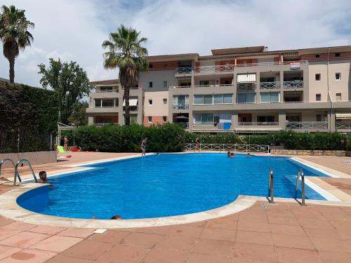 une grande piscine bleue devant un immeuble dans l'établissement T2 Proche Polygone - piscine, parking privé, fibre, à Cagnes-sur-Mer