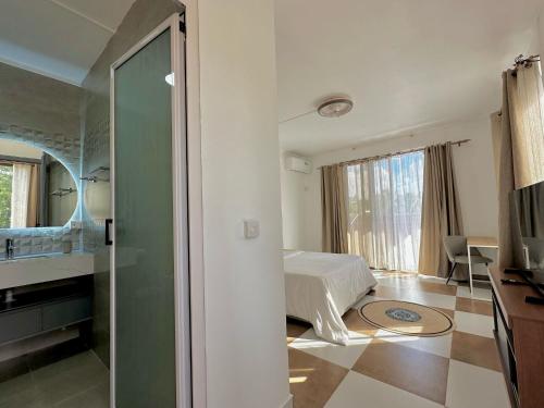 a hotel room with a bed and a bathroom at V&V Apartment in Belle Mare