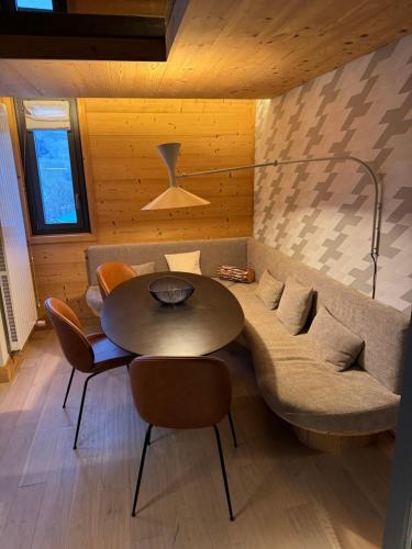 Cette chambre comprend un canapé, une table et des chaises. dans l'établissement Megeve les skis aux pieds, à Megève