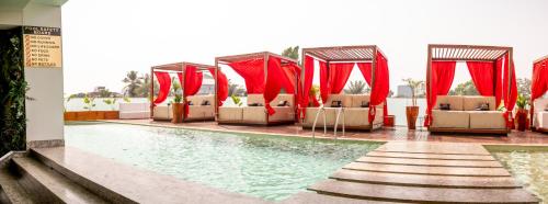 a hotel with a pool with chairs and tables at Number One Oxford Street Hotel & Suites in Accra