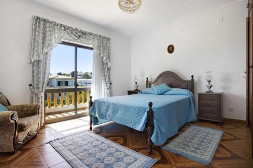 ein Schlafzimmer mit blauem Bett und Balkon in der Unterkunft Vivenda Ribeiro - B in Lagos
