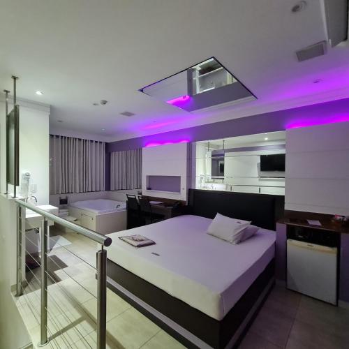 a bedroom with a large bed with purple lighting at Impulse Motel in São Bernardo do Campo