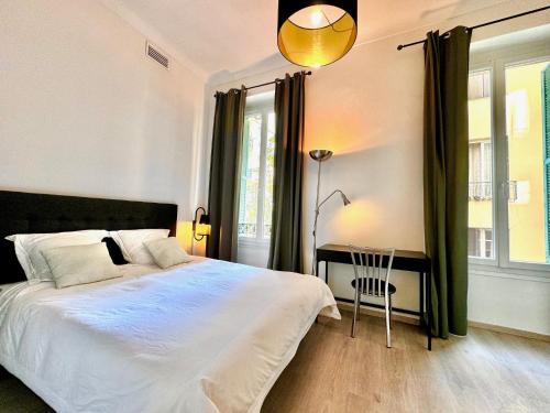 une chambre avec un lit, un bureau et une fenêtre dans l'établissement ApartHotel Riviera - Maison Alban - Old Port, à Nice