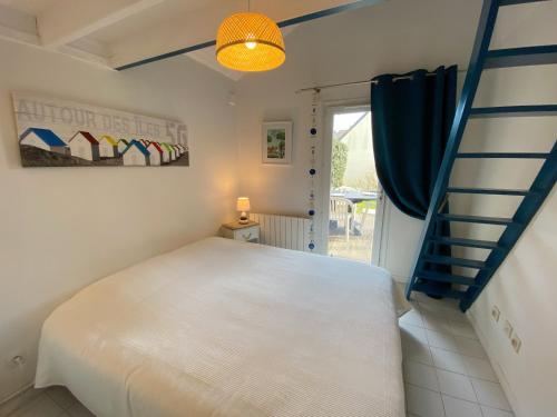 une chambre avec un lit blanc et un escalier dans l'établissement CALLEA 2 - Maison de vacances avec jardin Carnac - K16, à Carnac