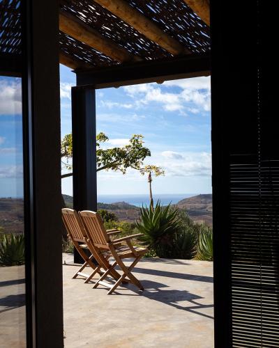 a pair of chairs sitting on a porch with a view at Buahjar Boutique Home Apartment in Agrigento
