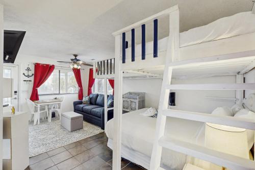 a bedroom with a bunk bed and a living room at Paradise Cove in Panama City Beach