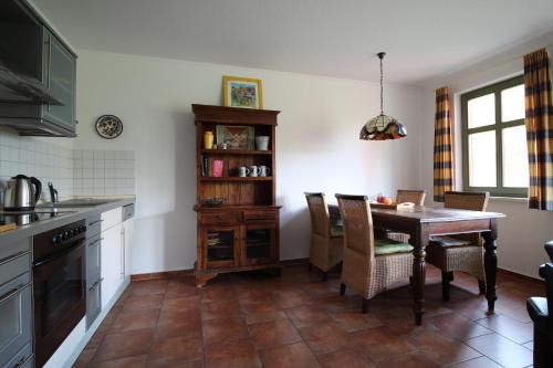 eine Küche mit einem Tisch und Stühlen in einer Küche in der Unterkunft Strandlöper in Wustrow
