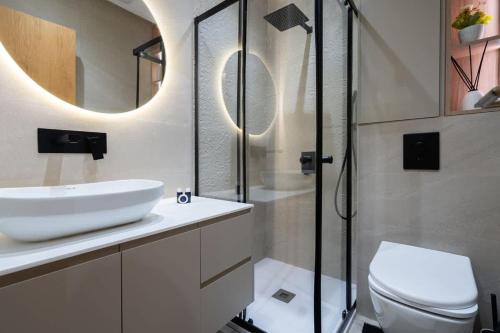 a bathroom with a sink and a toilet and a mirror at Appartement Élégant et Spacieux in LʼOasis