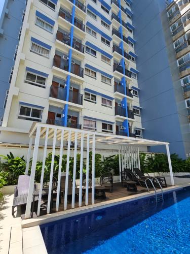 a swimming pool with a gazebo next to a building at Elegant Studio with balcony unit 625 - 6th floor - near Ateneo De Cebu - High speed internet - Northwoods Place in Mandaue City