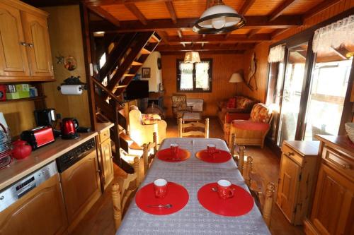 une cuisine avec une table et des plaques rouges. dans l'établissement Location magnifique chalet pour 10 personnes, aux Angles