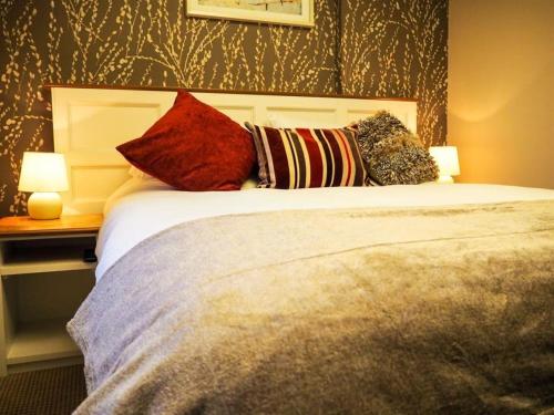 a bedroom with a bed with pillows on it at Parkwood Hotel in Stockton-on-Tees