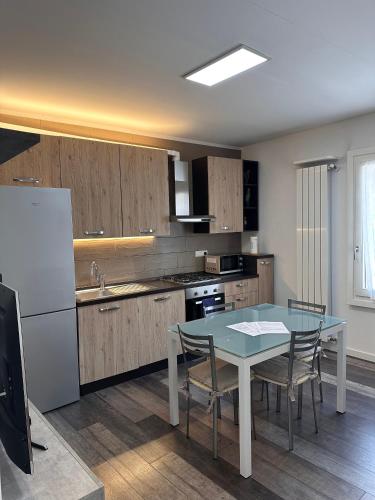 a kitchen with a table with chairs and a refrigerator at Melissa in Belluno