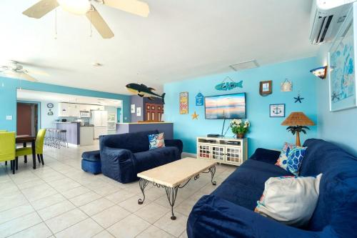 a living room with blue walls and a blue couch at Waterfront Beach House with Dock & Heated Pool in Summerland Key