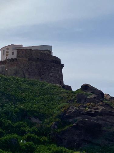 a castle on top of a grassy hill at Casa Grazia Apartment in Portoscuso