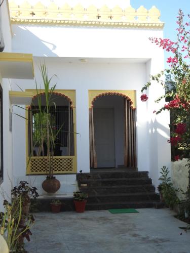 a white building with stairs and a door with plants at Jawai Leopard Villa in Bijāpur