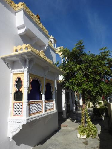 a white building with a tree in front of it at Jawai Leopard Villa in Bijāpur