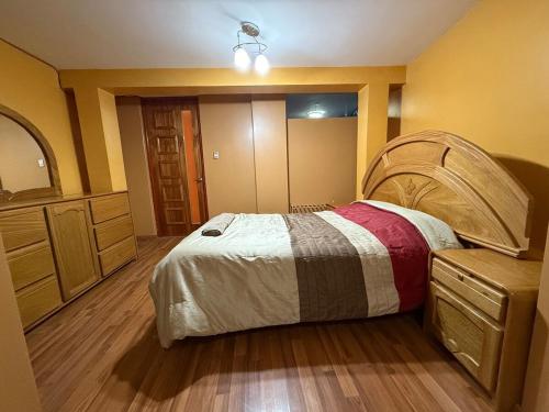 a bedroom with a large bed and a dresser at Amplio departamento con jacuzzi in Puno