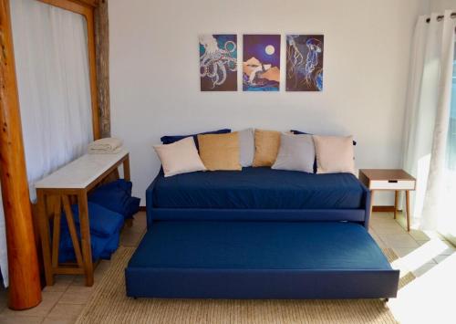 ein Wohnzimmer mit einem blauen Sofa und einem Tisch in der Unterkunft Driftwood Cottage By The Ocean Beach & Redwoods in Smith River