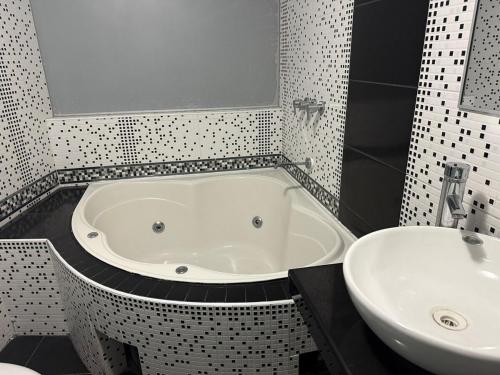 a bathroom with a bath tub and a sink at Amplio departamento con jacuzzi in Puno
