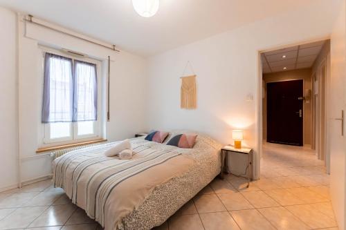 - une chambre avec un lit, une fenêtre et une lampe dans l'établissement Chez Margaux - Parking, à Colmar