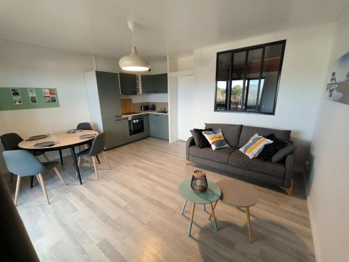 un salon avec un canapé et une table dans l'établissement Appartement Mimizan Plage, à Mimizan-Plage