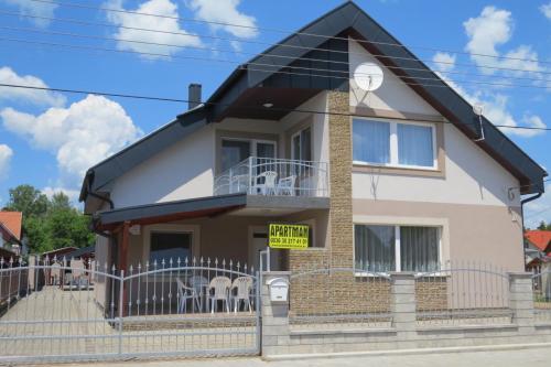 a house with a sign in front of it at 11 féröhelyes apartman in Balatonlelle