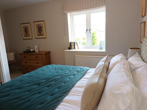 a bedroom with a bed with white sheets and a window at Baskerville House in Clyro